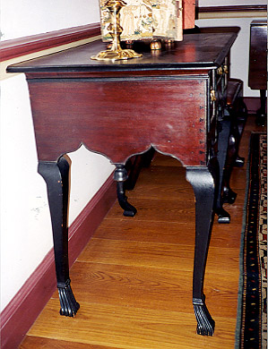 Detail four forward-facing carbiole legs on ankleted Spanish feet, dovetailing of case, and double-arched skirt with pendant