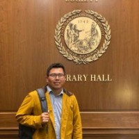 photo of Abelardo standing in front of APS Library Hall sign