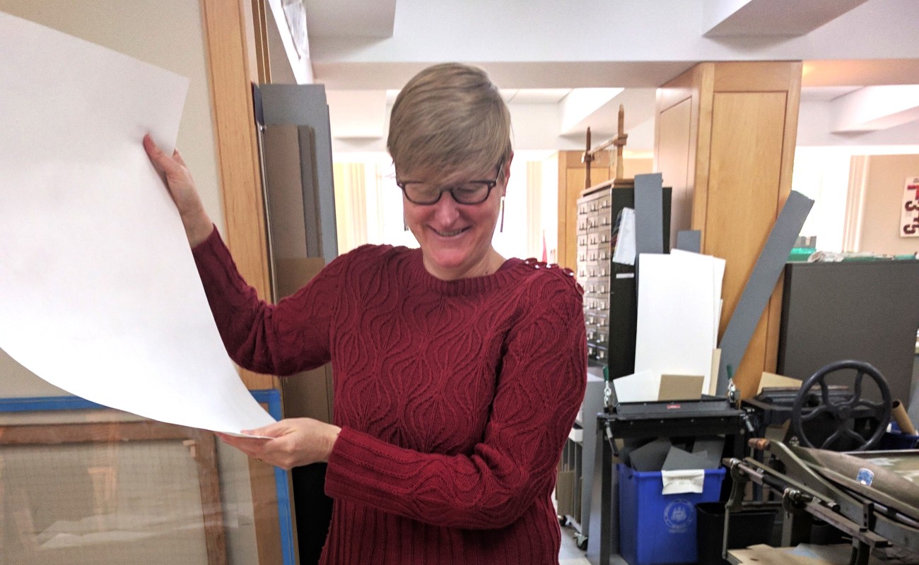 renee wolcott standing with documents being conserved