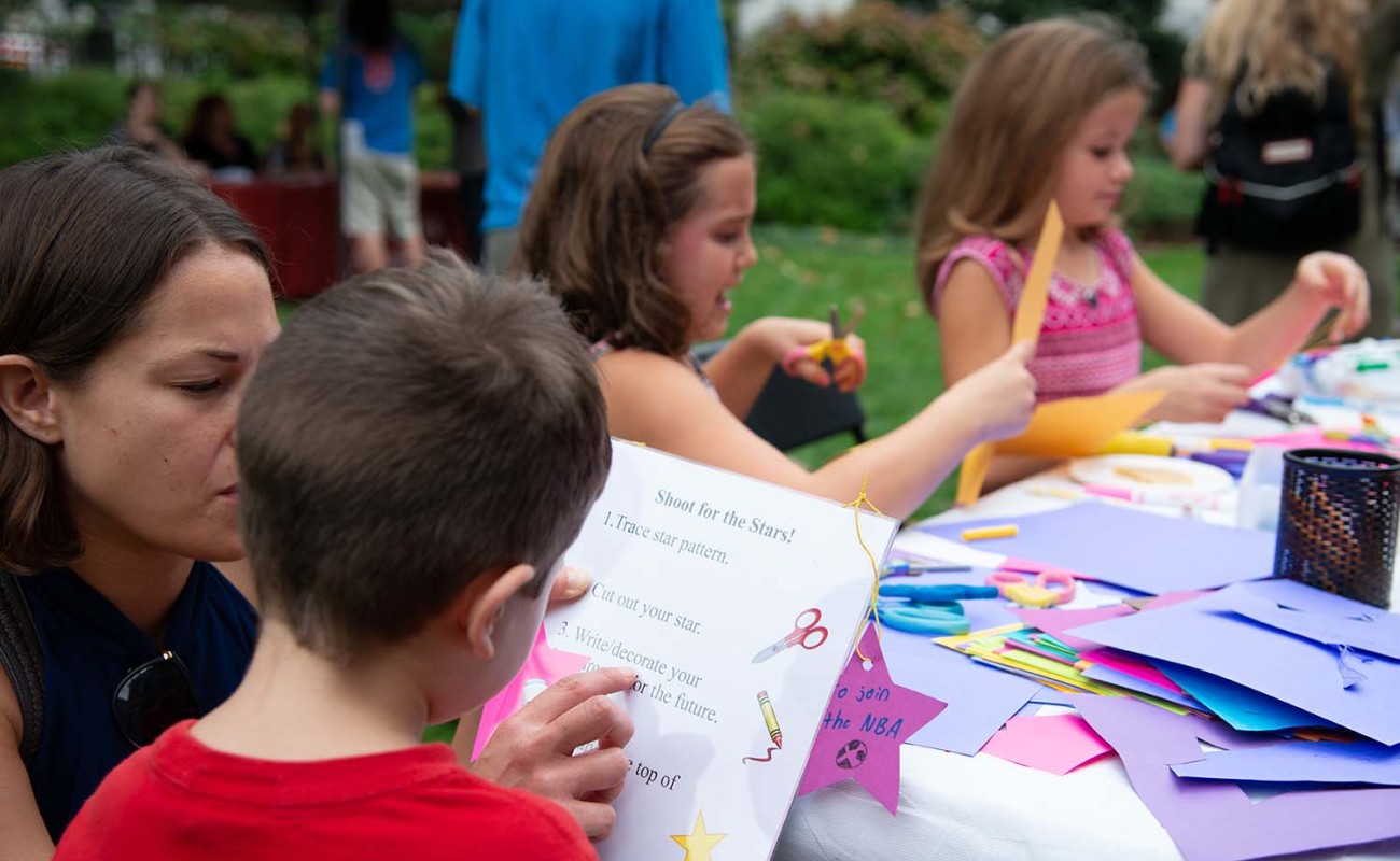 A picture of kids crafting paper stars at a table 