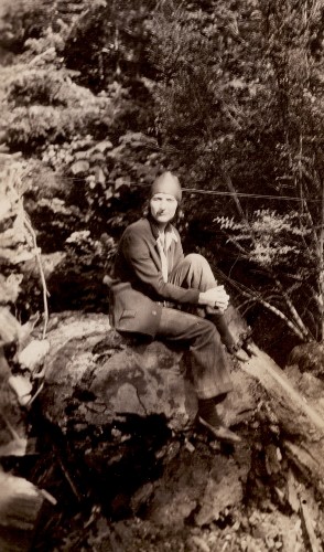 Mary R. Haas sitting on log